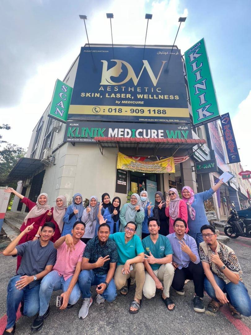 The clinic team celebrating in front of Klinik Medicure WLY.
